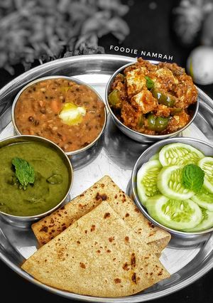 A picture of Punjabi Thali (dal makhani, paneer tikka gravy, mint chutney).