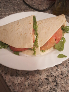 Una foto de Piadina con salmón, rúcula y pesto