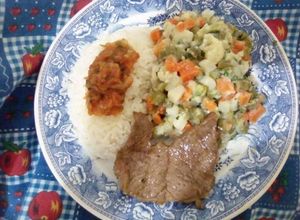 Una foto de Ensalada de verduras, con arroz blanco aderezado con hogao y carne asada