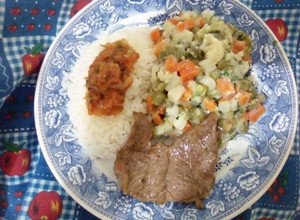 Una foto de Ensalada de verduras, con arroz blanco aderezado con hogao y carne asada
