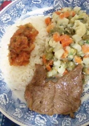 Una foto de Ensalada de verduras, con arroz blanco aderezado con hogao y carne asada