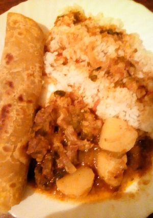 A picture of Beef stew served with chapati and rice.