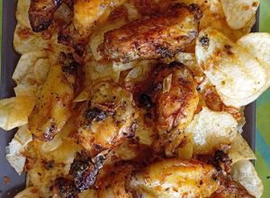 Foto principal de Alitas de pollo al limón con cebolla caramelizada en Airfryer sobre cama de patatas chips