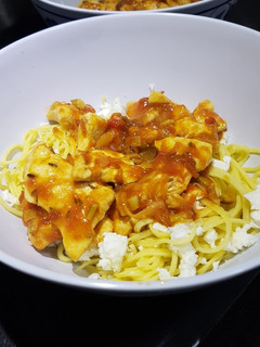 Una foto de Pechuga de pollo en salsa de tomate y jengibre con feta