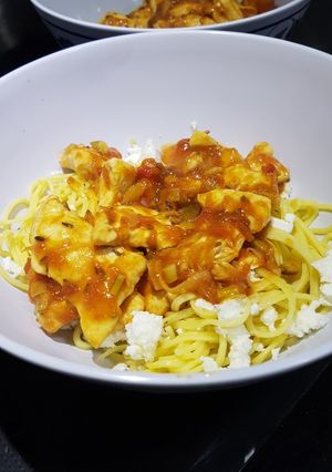 Una foto de Pechuga de pollo en salsa de tomate y jengibre con feta
