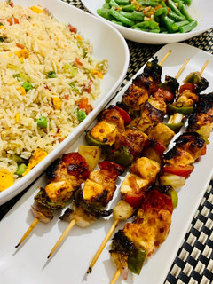 A picture of Chicken shashlik with cottage cheese serve with fried rice.