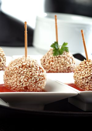 A picture of Chicken lollipops with tomato sauce.