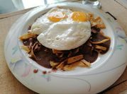 Una foto de chilaquiles con frijoles