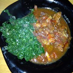 A picture of Beef stew with greens.