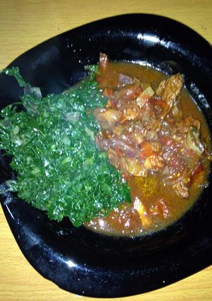 A picture of Beef stew with greens.