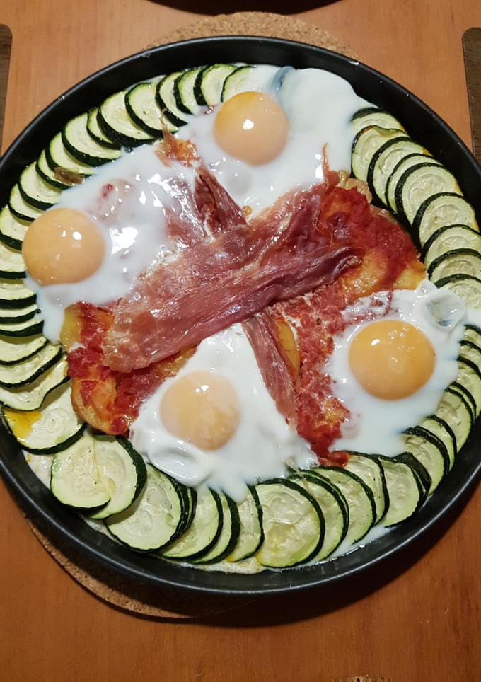 Una foto de Huevos al horno con calabacín y jamón