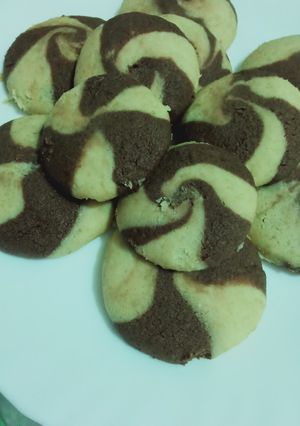 A picture of Two tone cookies with chocolate filled inside.