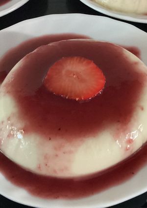 Una foto de Panna cotta con salsa de frutos rojos