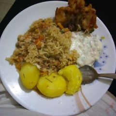A picture of Rosemary potatoes with rice, chicken and sauce.