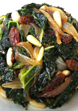 Una foto de Col kale salteada con uvas pasas y piñones - veggie