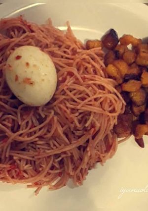 A picture of Spagetti with feied plantain and boiled egg.