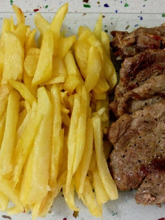 Una foto de Chuletas y lomo a la plancha con patatas fritas