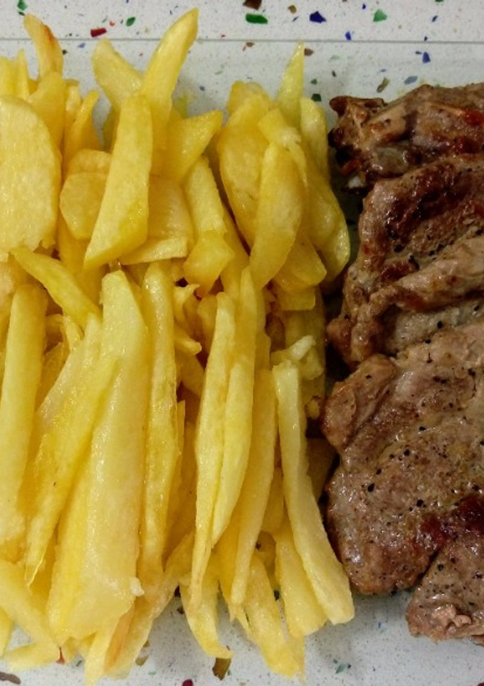 Una foto de Chuletas y lomo a la plancha con patatas fritas
