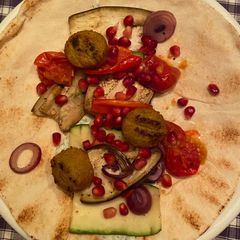 A picture of Lebanese flatbread with grilled veggies, falafel and tzatziki.