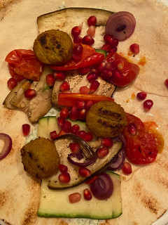A picture of Lebanese flatbread with grilled veggies, falafel and tzatziki.