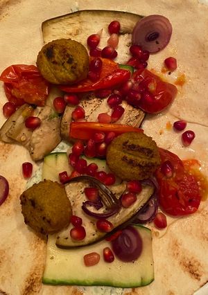 A picture of Lebanese flatbread with grilled veggies, falafel and tzatziki.