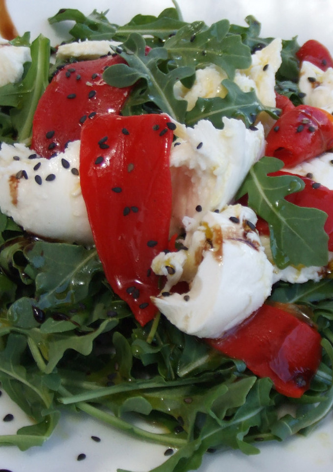 Una foto de Ensalada de rúcula con burrata y pimientos asados
