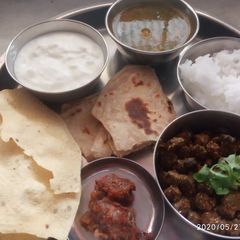 A picture of Veg thali - besanbhindi, tur dal, rice, parantha.