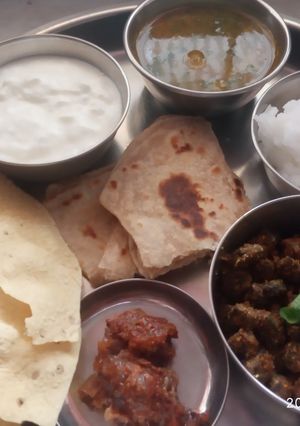 A picture of Veg thali - besanbhindi, tur dal, rice, parantha.