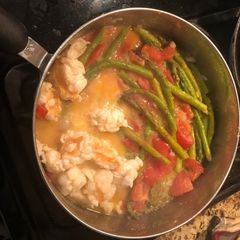A picture of Sautéed lobster, tomatoes and asparagus with a lemon butter sauce.