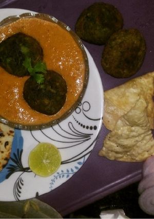 A picture of Palak kofta in red Gravy with Garlic naan.