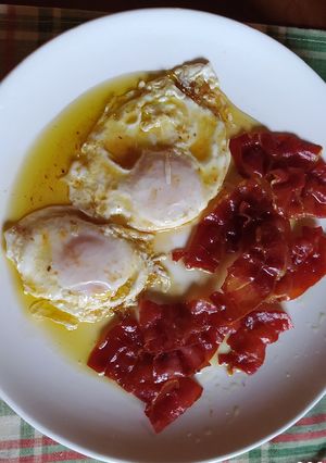 Una foto de Huevos fritos con jamón ibérico crujiente y miel