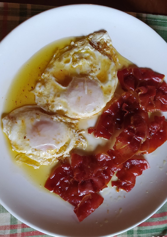 Una foto de Huevos fritos con jamón ibérico crujiente y miel