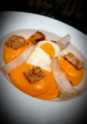 Une photo de Œuf parfait, espuma chorizo, pickles d'oignons et condiment citron