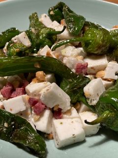 Una foto de Ensalada de pimientos de Padrón con taquitos de jamón ibérico y queso fresco de cabra