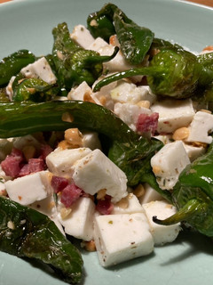 Una foto de Ensalada de pimientos de Padrón con taquitos de jamón ibérico y queso fresco de cabra