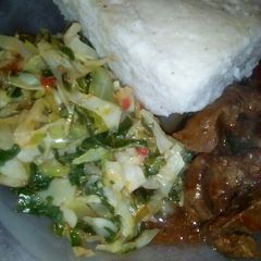 A picture of Cabbage and spinach served with ugali and liver.