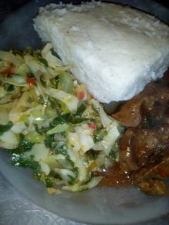 A picture of Cabbage and spinach served with ugali and liver.