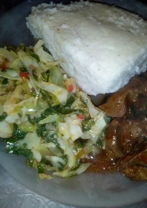 A picture of Cabbage and spinach served with ugali and liver.