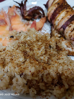 Una foto de Calamar a la plancha, con chimichurri, tajín y arroz frito