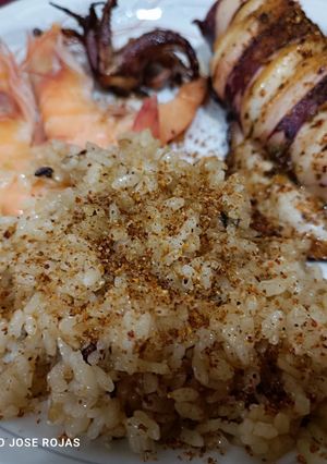 Una foto de Calamar a la plancha, con chimichurri, tajín y arroz frito