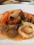 Zuppa di Calamari e Gamberoni con Pomodorini e Olive Verde su Crostone di Pane