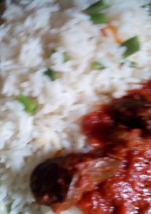 A picture of White rice and green peas with stew.
