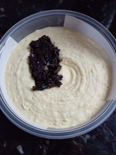 Una foto de Hummus con aceitunas negras