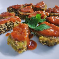 A picture of Parsley Lauki muthiya topped with pizza sezhwan sauce.