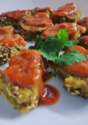 A picture of Parsley Lauki muthiya topped with pizza sezhwan sauce.