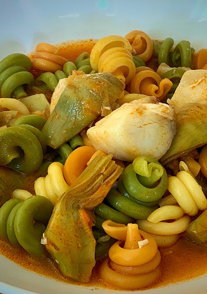 Una foto de Pasta, pescado, su caldo y alcachofa