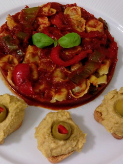 Una foto de Cappellettis de jamón con salsa de tomate y hummus con aceitunas