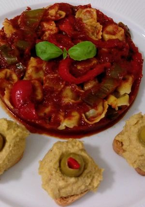 Una foto de Cappellettis de jamón con salsa de tomate y hummus con aceitunas