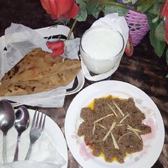 A picture of Beef Achari Qeema with square Parantha.