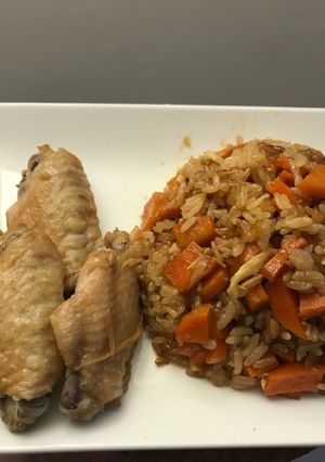 A picture of Rice with carrots and chicken wings.